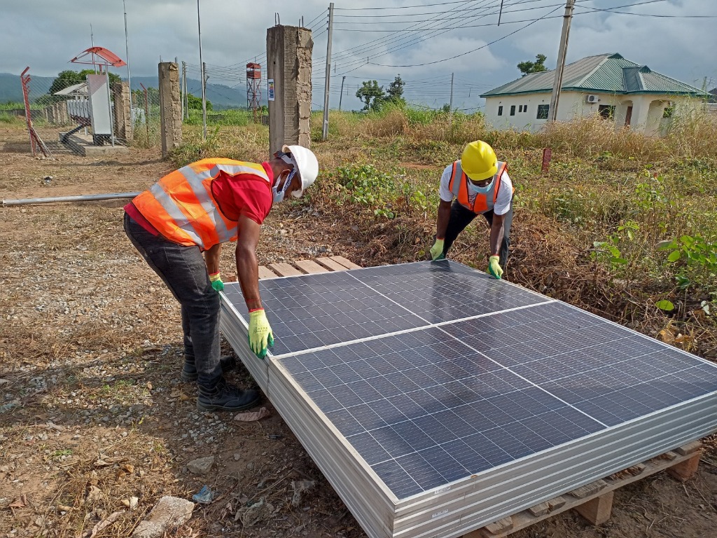 Jacbit team handling solar panels